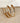 Gold hoop earrings on a textured beige surface with a white fabric background
