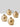 Set of three gold metallic vases on a white surface with a light gray background