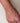 Hand wearing a diamond bracelet on a neutral background